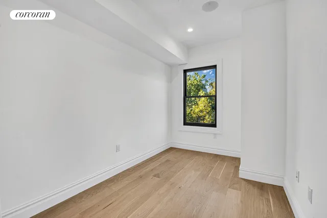 a view of room with window and wooden floor