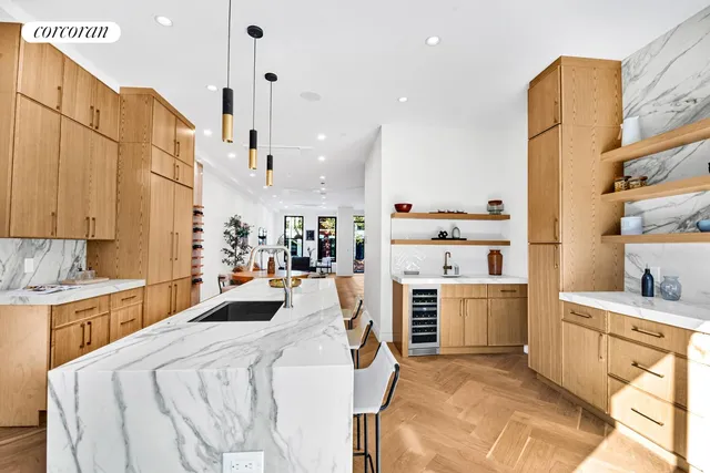 a kitchen with stainless steel appliances granite countertop a refrigerator a oven and white cabinets with wooden floors