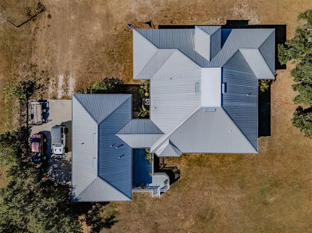a view of a house with backyard and trees