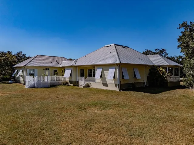 an aerial view of house with yard and mountain view in back
