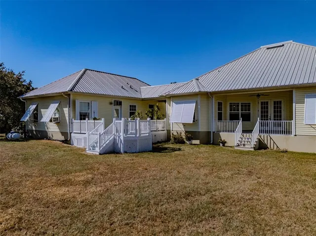 a view of a yard with a table and chairs under an umbrella