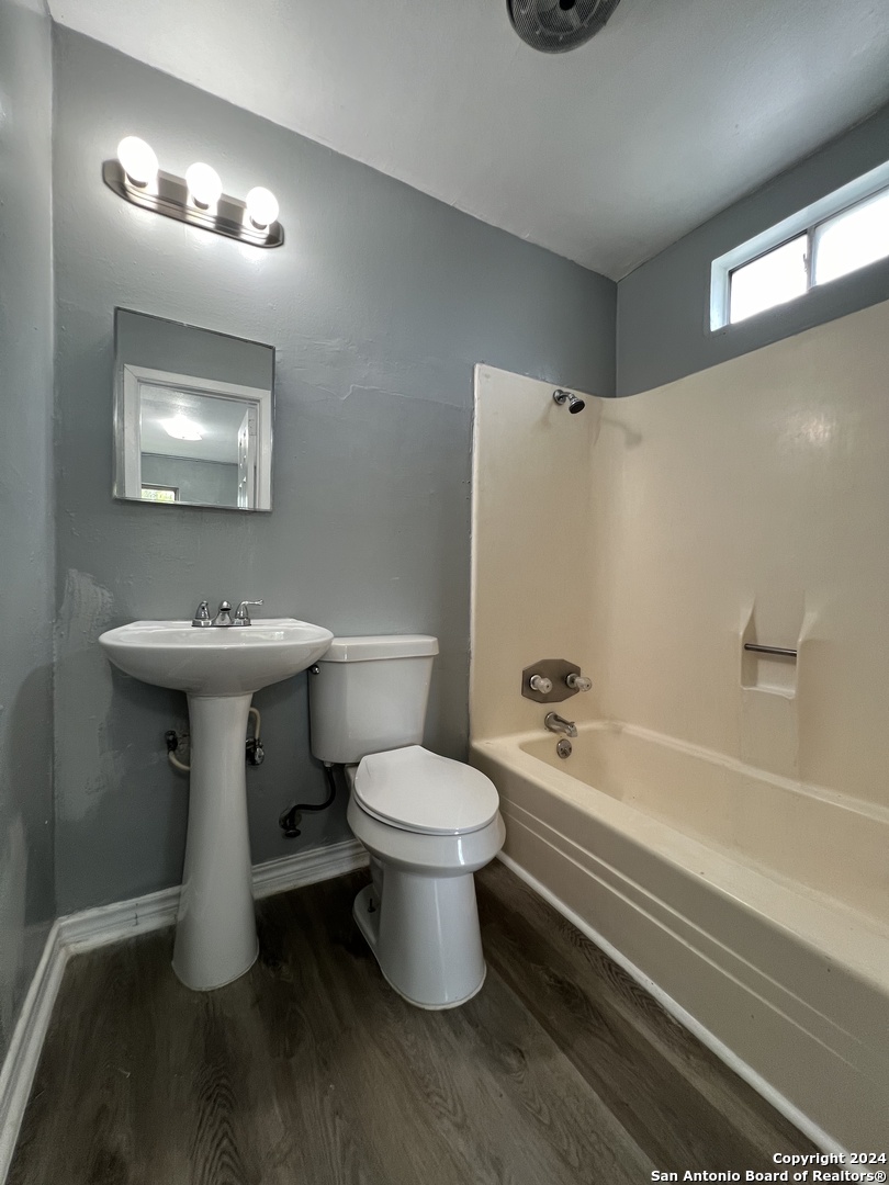 1723 West Mayfield Boulevard, Unit 4 San Antonio, TX 78211 - Photo 12 of 14 a bathroom with a sink toilet and shower