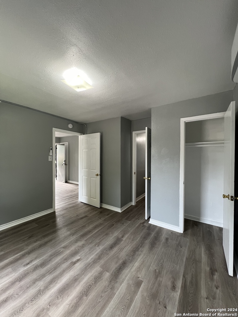 1723 West Mayfield Boulevard, Unit 4 San Antonio, TX 78211 - Photo 10 of 14 an empty room with wooden floor & windows and bathroom