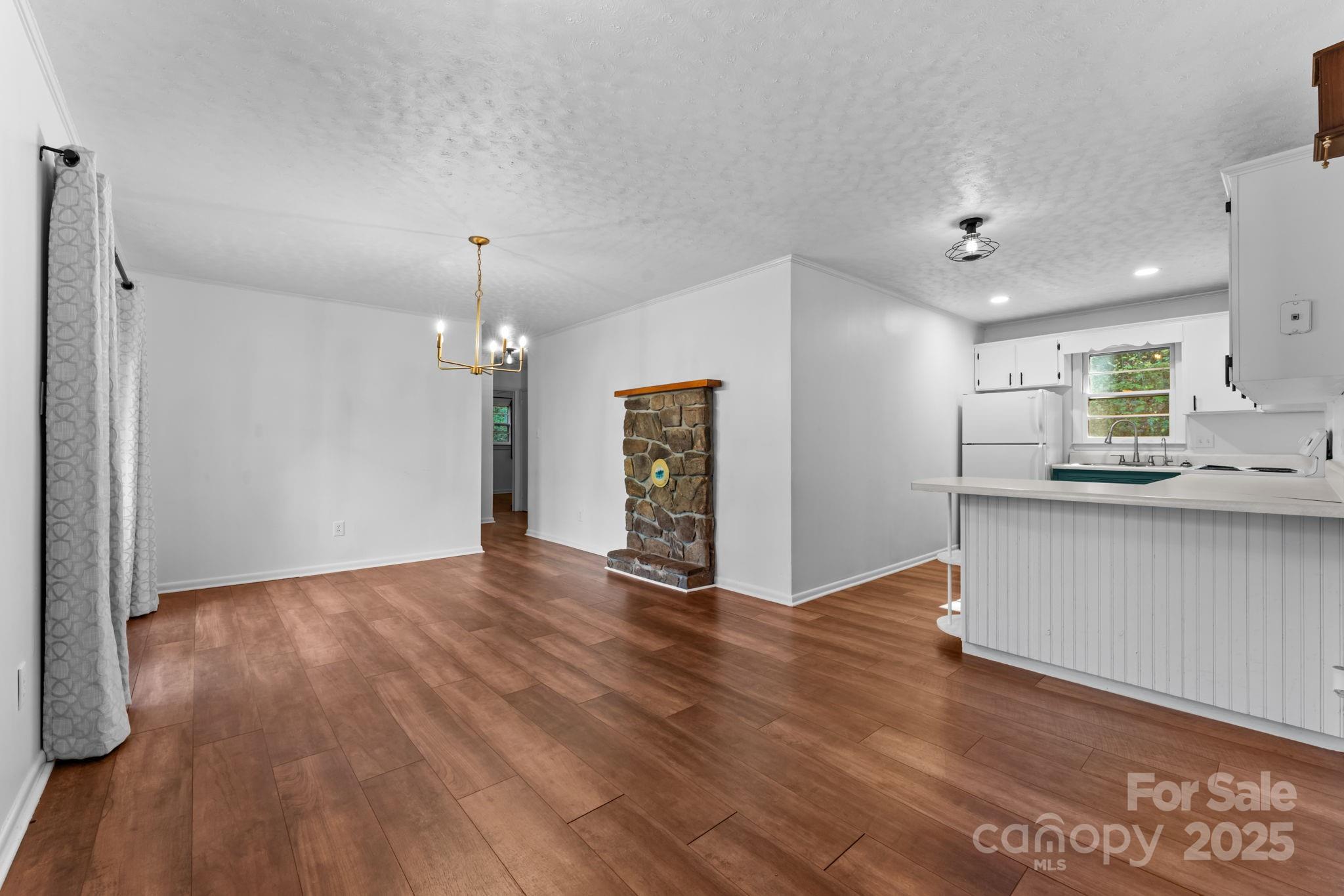 621 Kitchens Branch Road Sylva, NC 28779 - Photo 12 of 29 an empty room with wooden floor and windows