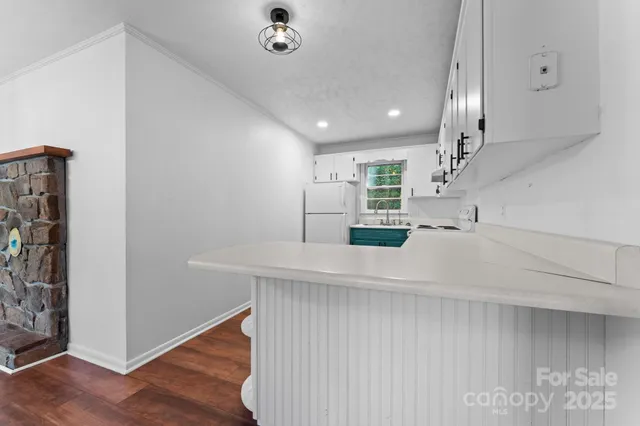 a kitchen with stainless steel appliances a refrigerator and wooden floor