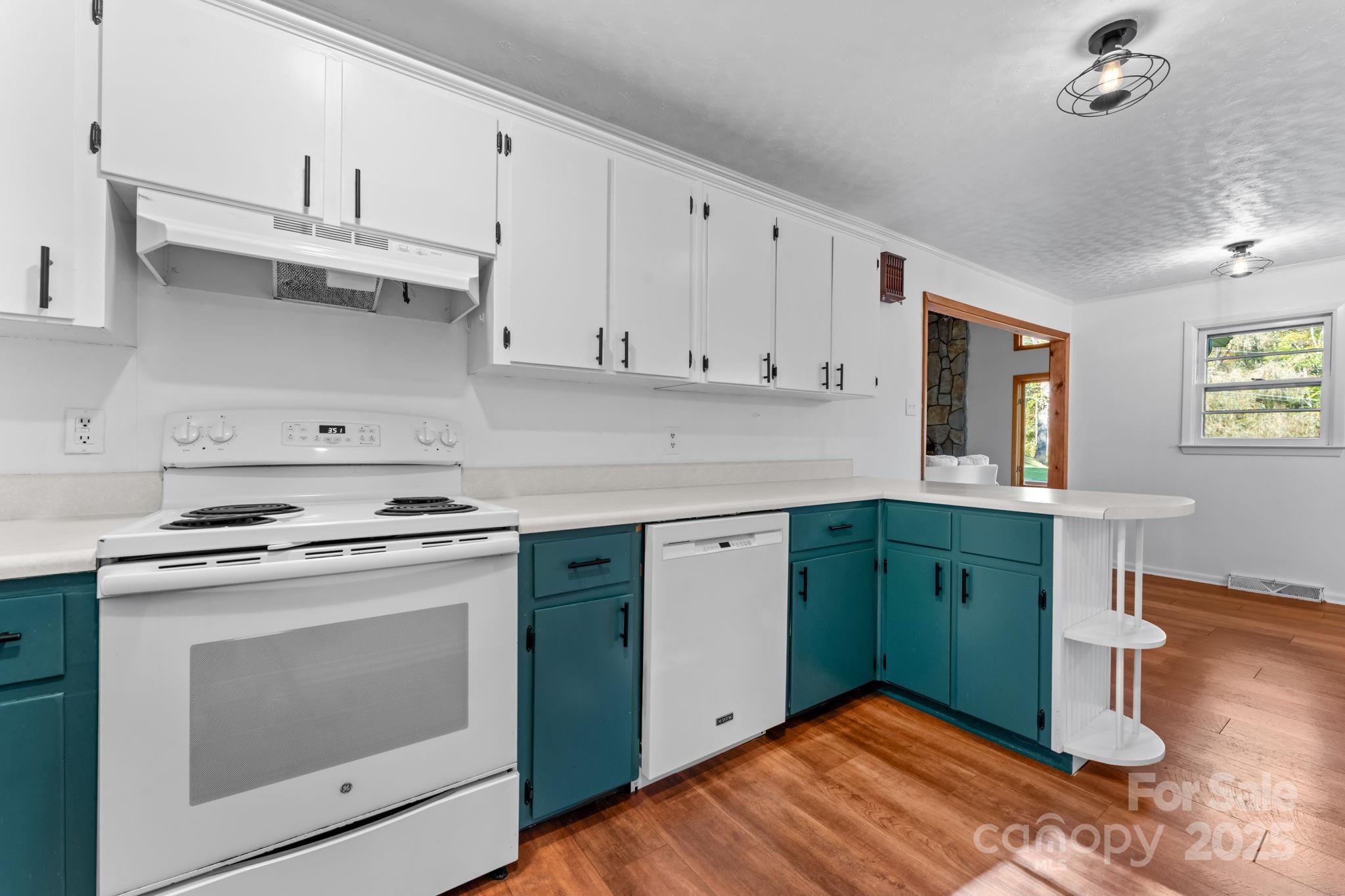 621 Kitchens Branch Road Sylva, NC 28779 - Photo 15 of 29 a kitchen with granite countertop a stove a sink and dishwasher with white cabinets
