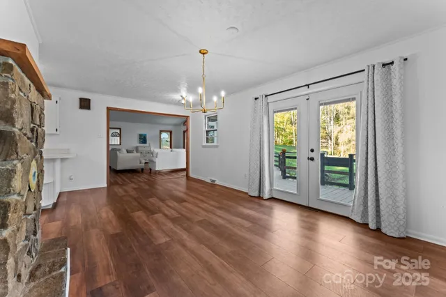 a view of a big room with wooden floor and windows