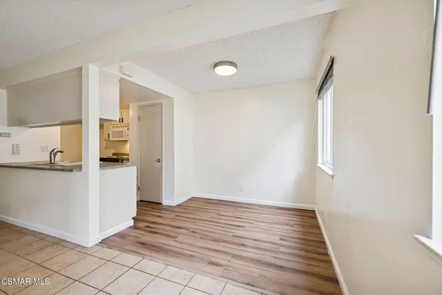 a view of a hallway to room with wooden floor