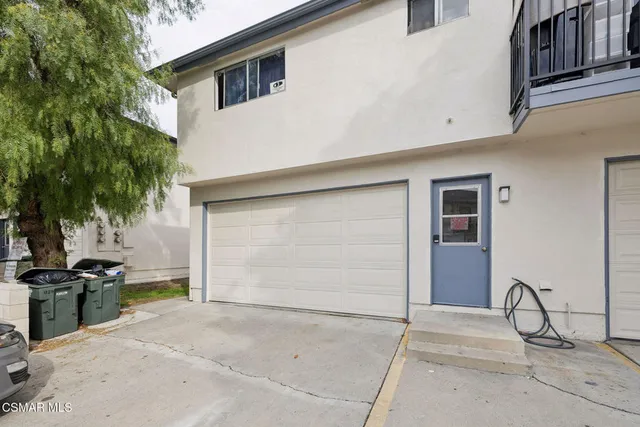 a view of a kitchen with sink and refrigerator