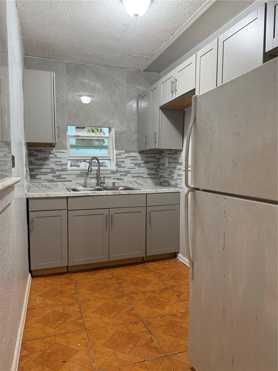 1918 Northwest 82nd Street Miami, FL 33147 - Photo 11 of 15 a kitchen with stainless steel appliances a sink stove and refrigerator