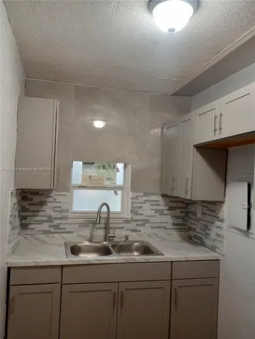 a kitchen with sink and cabinets