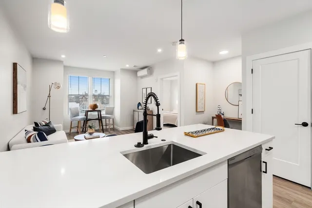a kitchen with a sink a counter and chairs