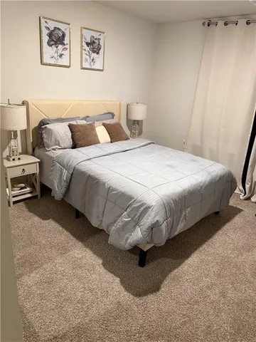 a bedroom with a bed and a painting on the wall