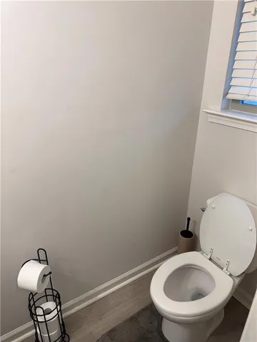 a bathroom with a toilet and a chair