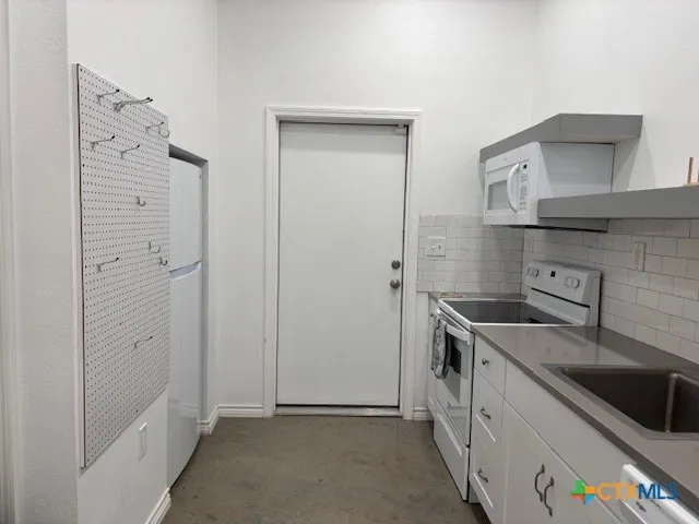 a kitchen with stainless steel appliances granite countertop a sink and a refrigerator