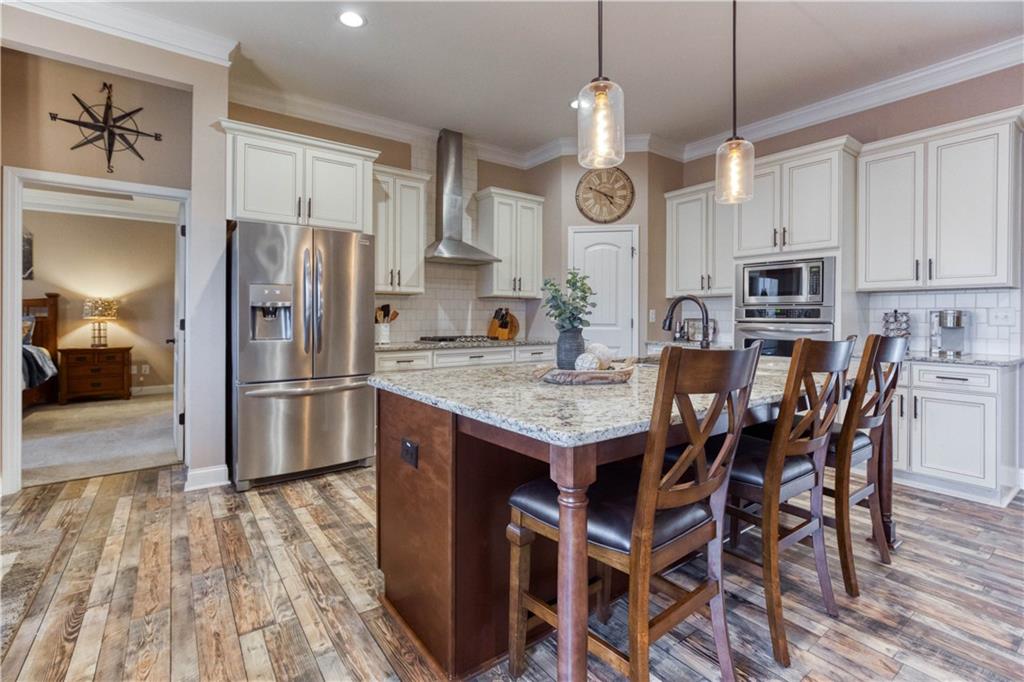 390 Herring Road Grayson, GA 30017 - Photo 22 of 59 a kitchen with granite countertop a table chairs stainless steel appliances and cabinets