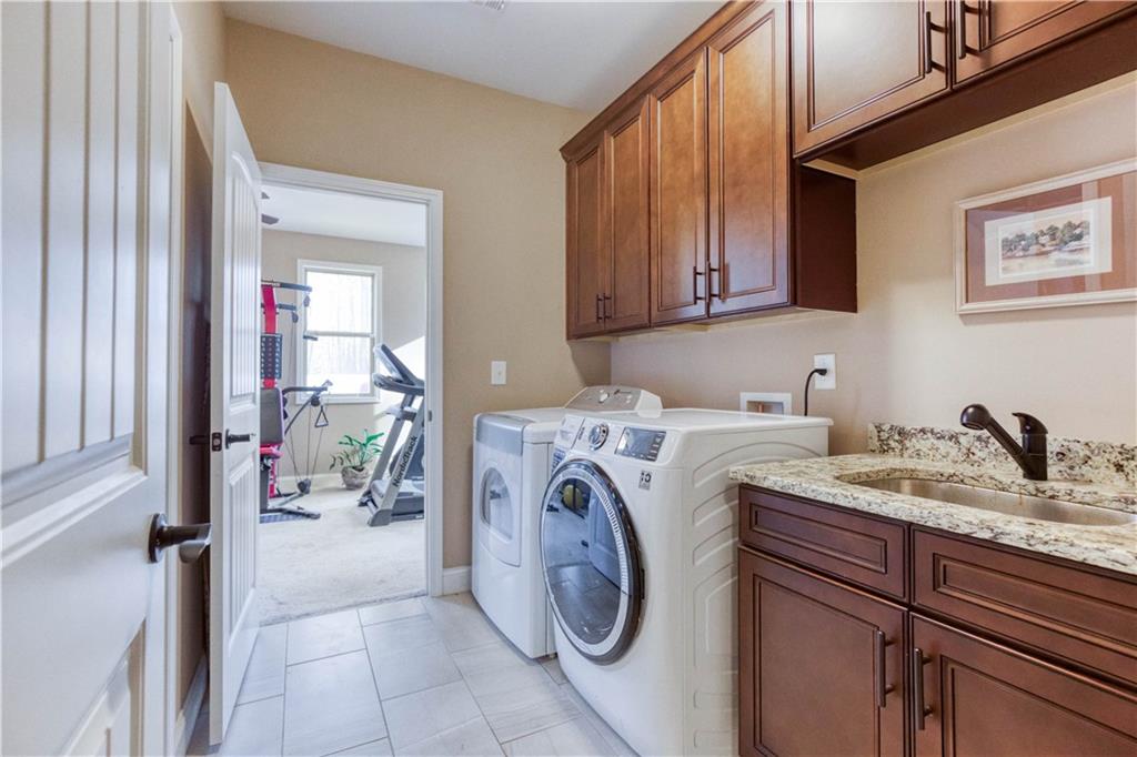 390 Herring Road Grayson, GA 30017 - Photo 30 of 59 a utility room with sink dryer and washer