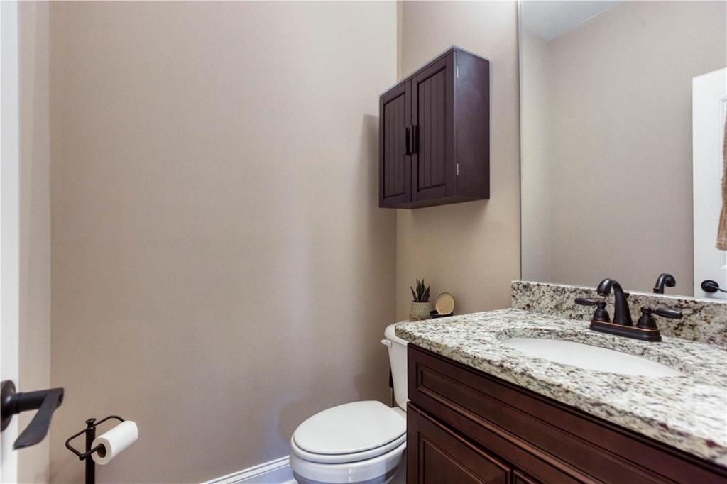 390 Herring Road Grayson, GA 30017 - Photo 38 of 59 a bathroom with a granite countertop toilet sink and mirror