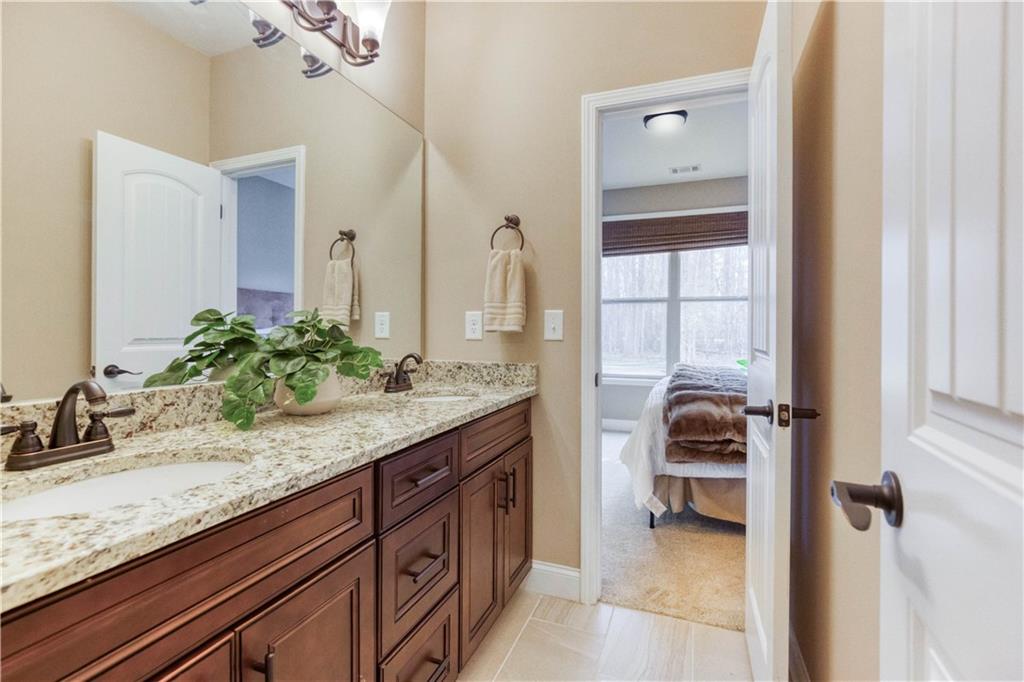 390 Herring Road Grayson, GA 30017 - Photo 41 of 59 a en suite bathroom with a granite countertop sink and a mirror