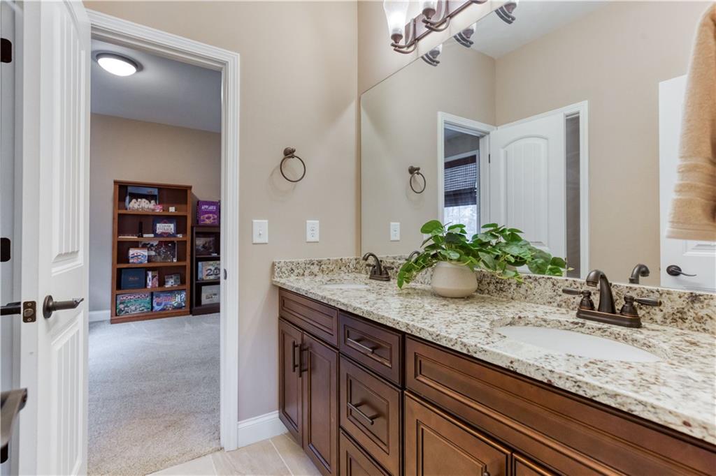 390 Herring Road Grayson, GA 30017 - Photo 42 of 59 a bathroom with a granite countertop sink and a mirror