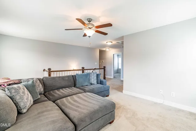 a living room with furniture and a ceiling fan