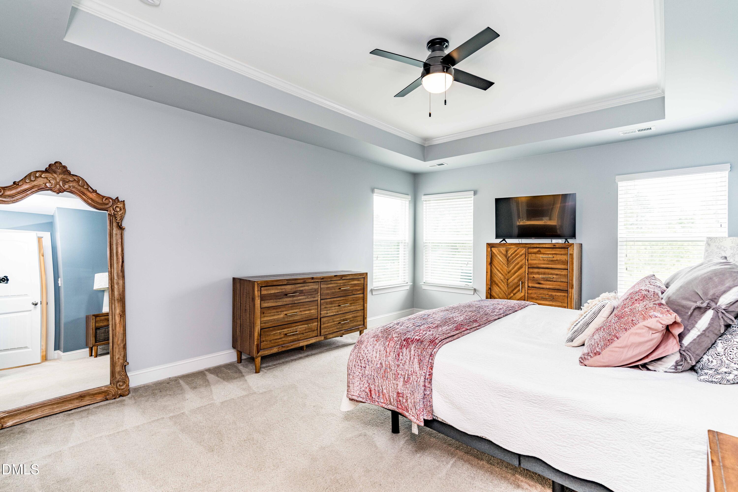 5405 Weathered Rock Court Knightdale, NC 27545 - Photo 24 of 36 a bedroom with a bed ceiling fan and a dresser