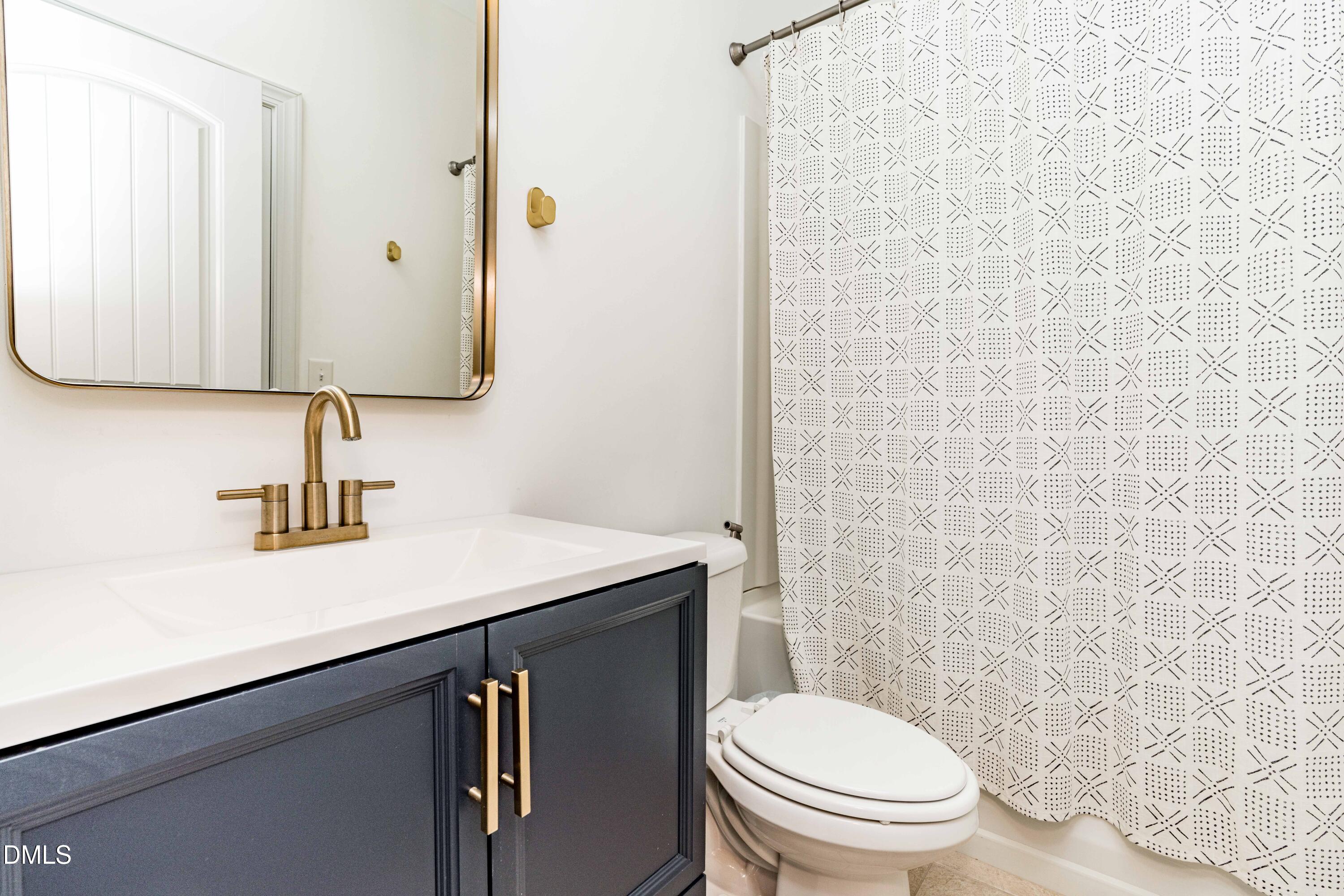 5405 Weathered Rock Court Knightdale, NC 27545 - Photo 30 of 36 a bathroom with a sink a toilet and mirror