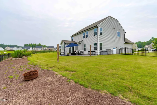a view of a swimming pool with lawn chairs and a big yard
