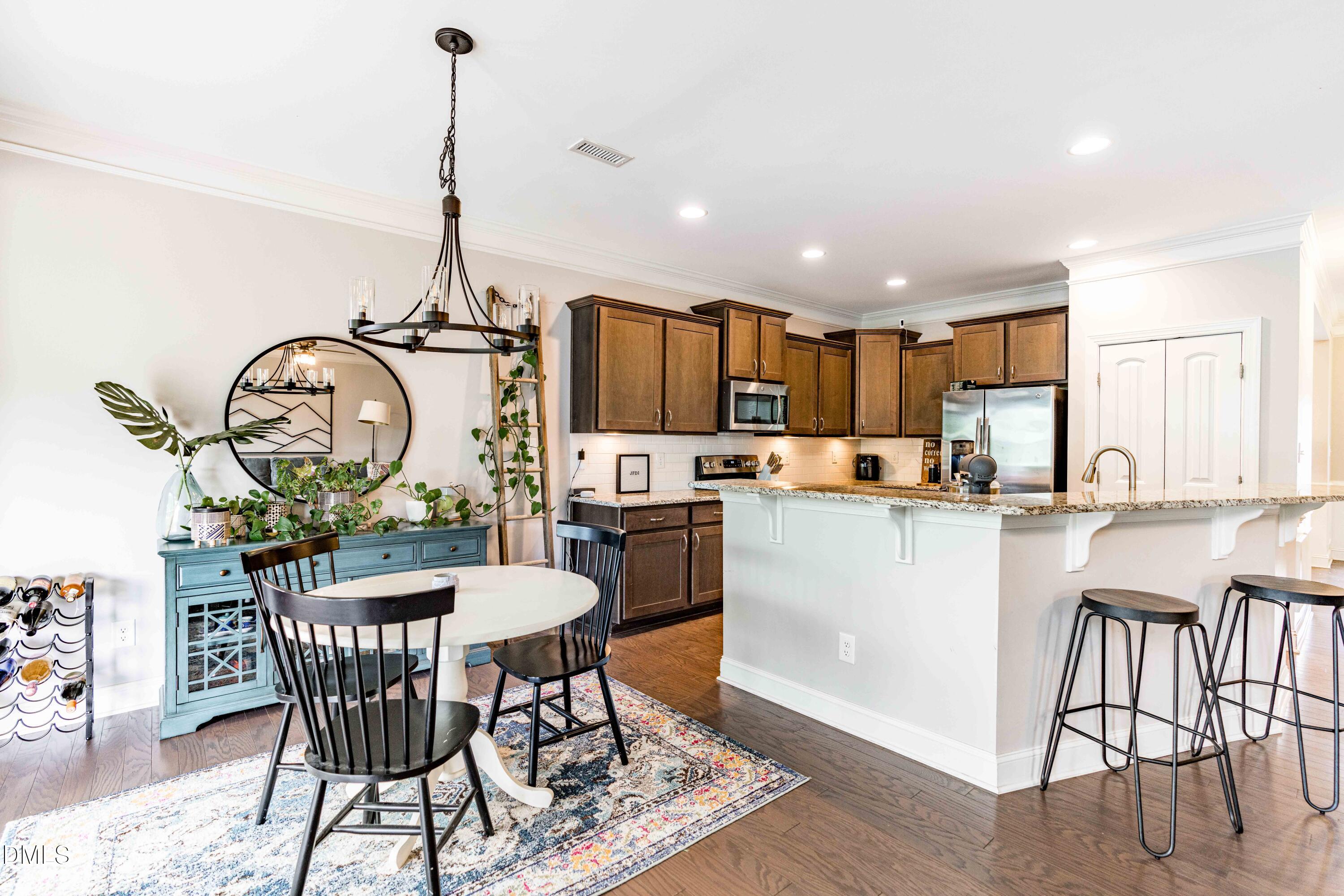 5405 Weathered Rock Court Knightdale, NC 27545 - Photo 5 of 36 a kitchen with a table chairs appliances and cabinets