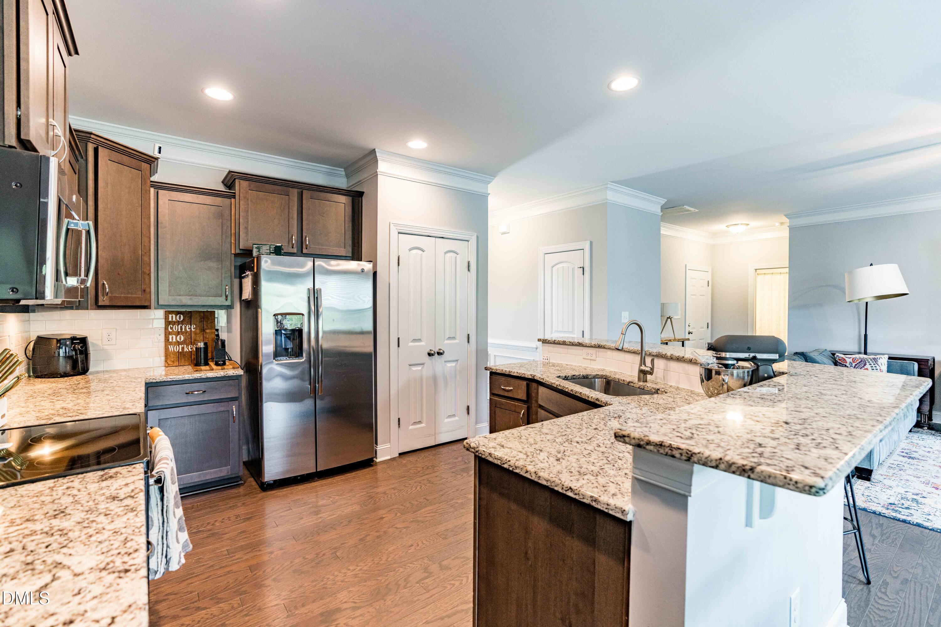 5405 Weathered Rock Court Knightdale, NC 27545 - Photo 6 of 36 a kitchen with stainless steel appliances granite countertop a sink stove and refrigerator