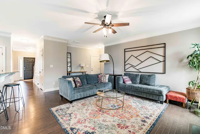 a living room with furniture and a wooden floor