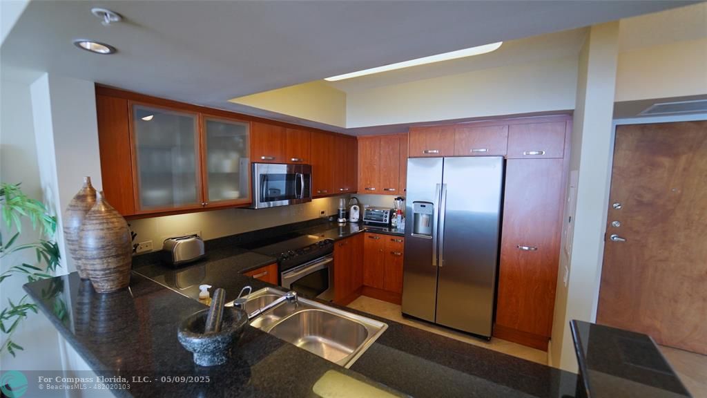 2011 North Ocean Boulevard, Unit 1606 Fort Lauderdale, FL 33305 - Photo 11 of 30 a kitchen with stainless steel appliances granite countertop a refrigerator and a sink