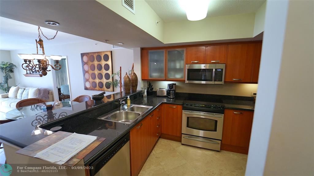 2011 North Ocean Boulevard, Unit 1606 Fort Lauderdale, FL 33305 - Photo 22 of 30 a kitchen with a stove a sink and a microwave