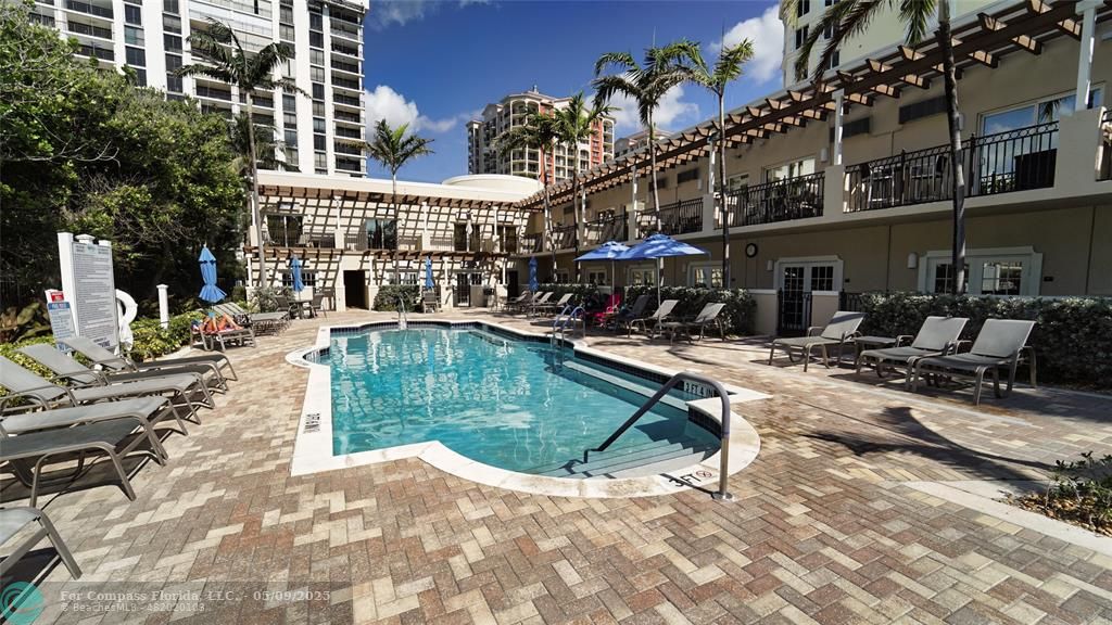 2011 North Ocean Boulevard, Unit 1606 Fort Lauderdale, FL 33305 - Photo 3 of 30 a view of a swimming pool with a lounge chairs in front of a house