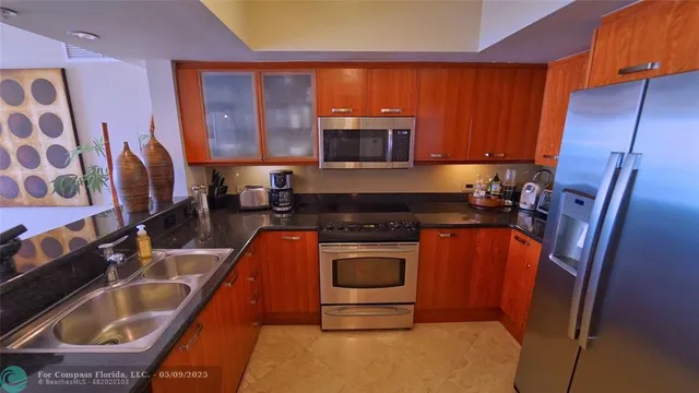 a kitchen with stainless steel appliances granite countertop a sink stove and refrigerator