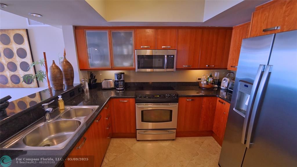 2011 North Ocean Boulevard, Unit 1606 Fort Lauderdale, FL 33305 - Photo 10 of 30 a kitchen with stainless steel appliances granite countertop a sink stove and refrigerator