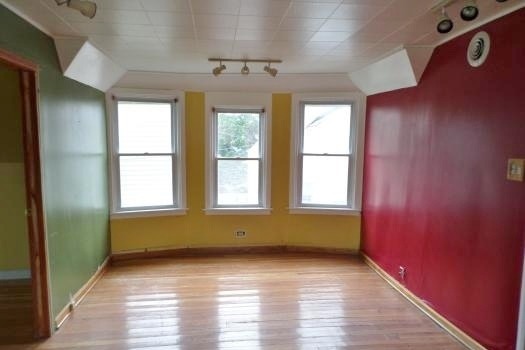 2210 North Keating Avenue Chicago, IL 60639 - Photo 3 of 10 a view of empty room with wooden floor and fan