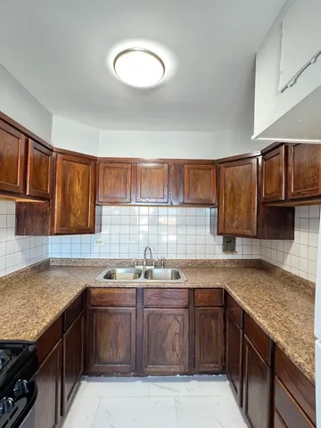 a kitchen with a sink a stove and cabinets