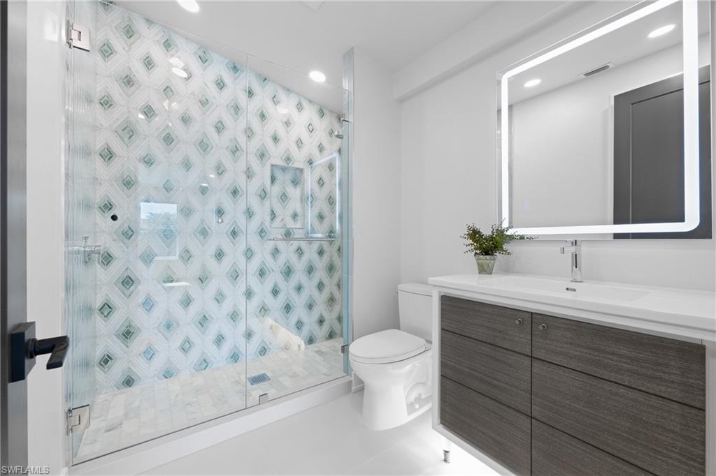 1836 Harbor Lane Naples, FL 34104 - Photo 21 of 40 a bathroom with a sink and a mirror