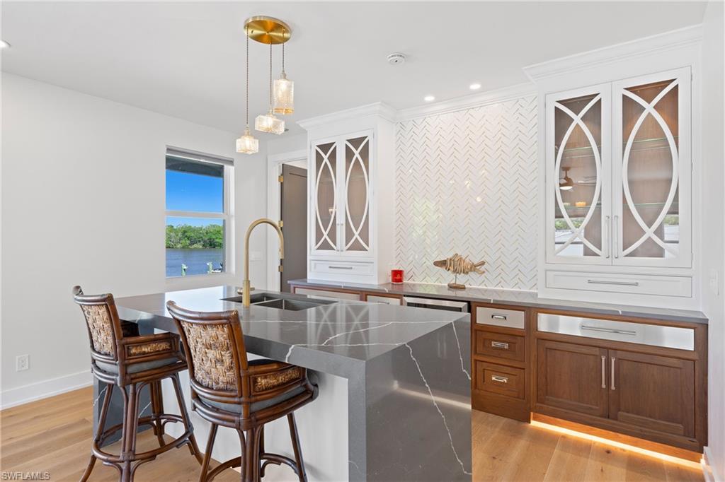 1836 Harbor Lane Naples, FL 34104 - Photo 30 of 40 a view of a kitchen with granite countertop a dining table chairs and a chandelier