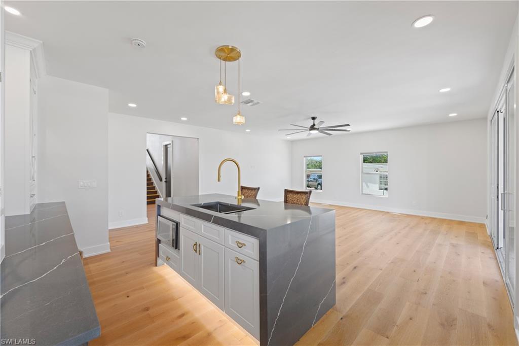 1836 Harbor Lane Naples, FL 34104 - Photo 31 of 40 a large kitchen with stainless steel appliances a large counter top a chandelier and a view of living room