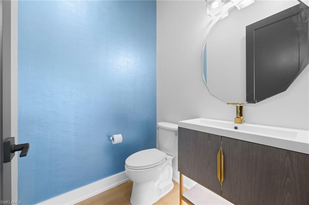 1836 Harbor Lane Naples, FL 34104 - Photo 35 of 40 a bathroom with a sink a toilet and mirror