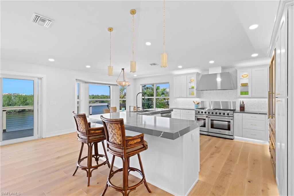 1836 Harbor Lane Naples, FL 34104 - Photo 9 of 40 a kitchen with stainless steel appliances kitchen island granite countertop a stove top oven a sink with island and chairs