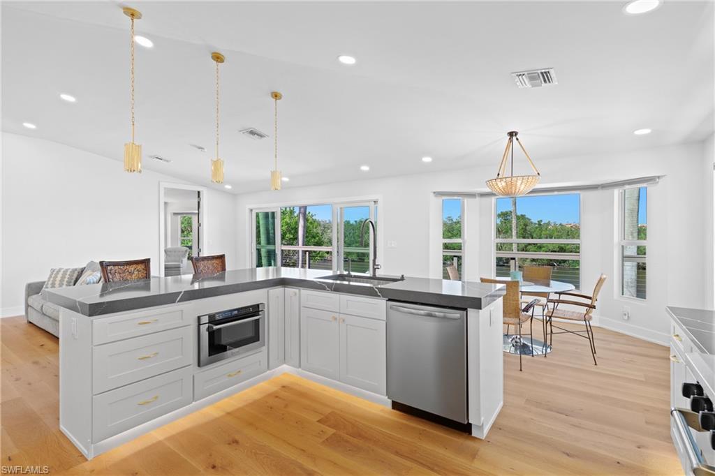 1836 Harbor Lane Naples, FL 34104 - Photo 10 of 40 a kitchen with stainless steel appliances granite countertop a stove and chairs
