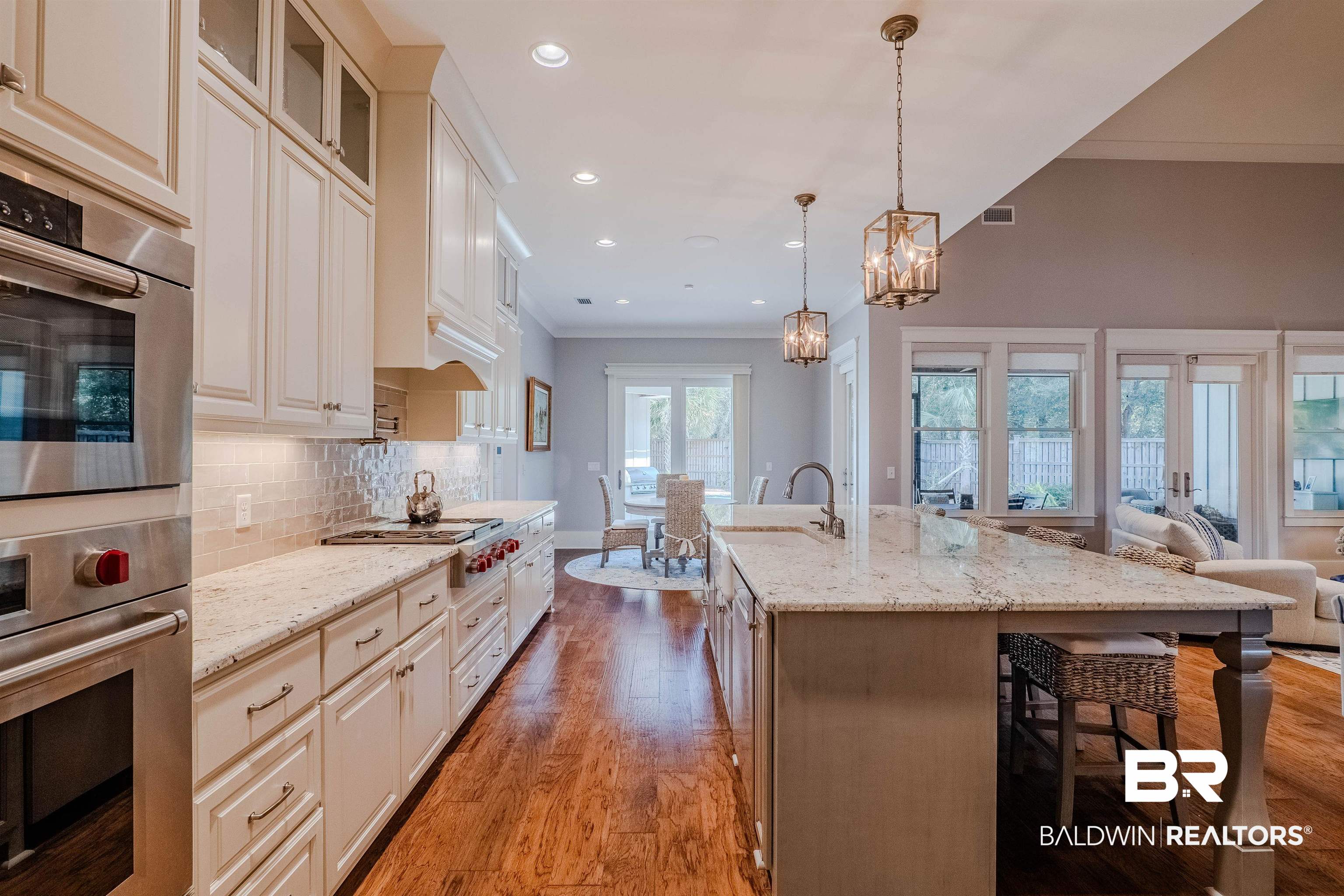 708 Manning Place Fairhope, AL 36532 - Photo 9 of 58 Kitchen with an island with sink, a breakfast bar area, hanging light fixtures, light stone counters, and stainless steel appliances