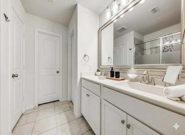 a en suite bathroom with a double vanity sink and mirror