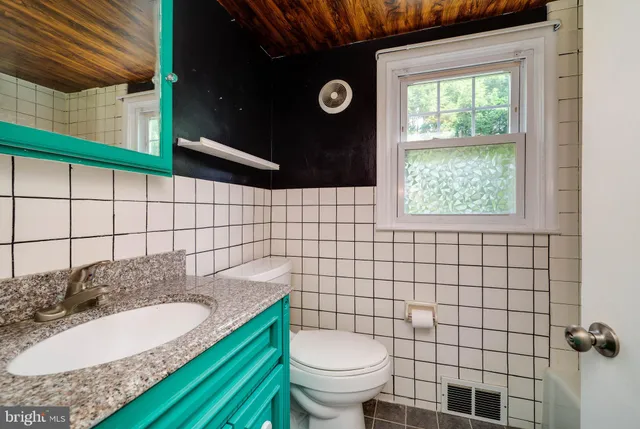 a bathroom with a sink a toilet and mirror