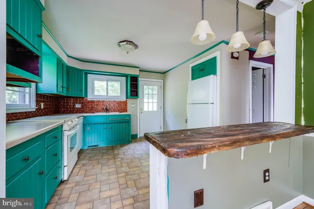 a kitchen with kitchen island a sink stove and refrigerator
