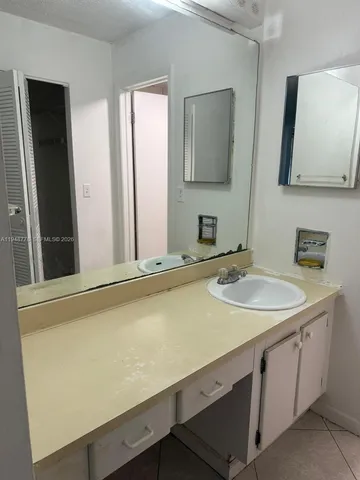 a bathroom with a granite countertop shower and a sink