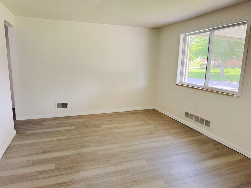 279 Olympic Road Pittsburgh, PA 15236 - Photo 4 of 25 a view of an empty room with wooden floor and a window